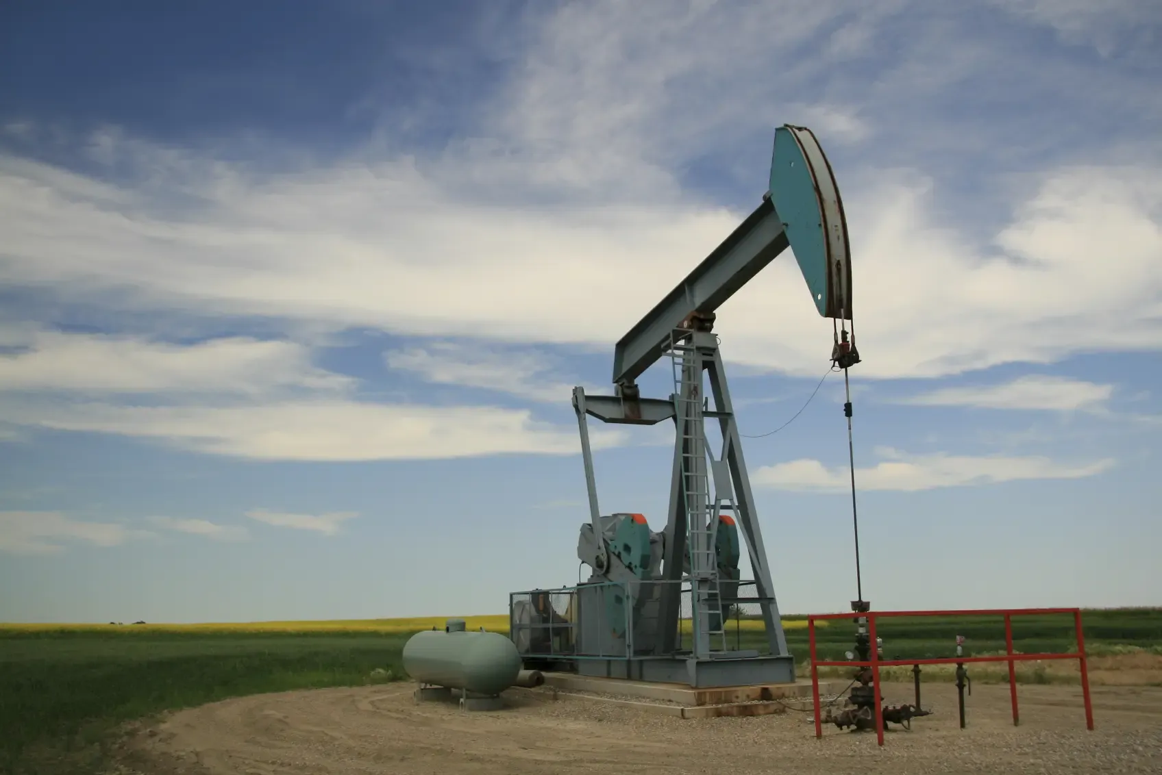 Pumpjack at oil well site in summer field