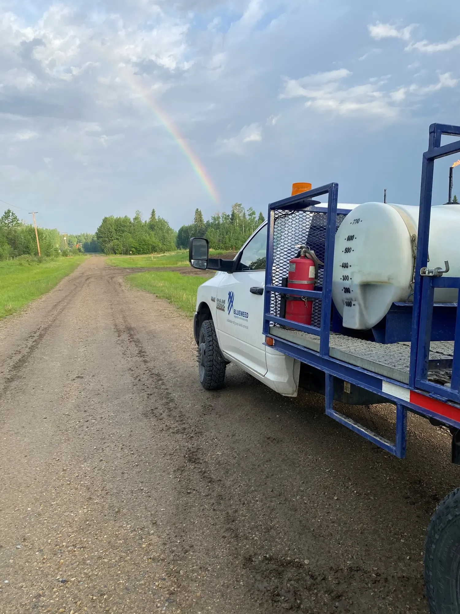 Spray truck on road with rainbow
